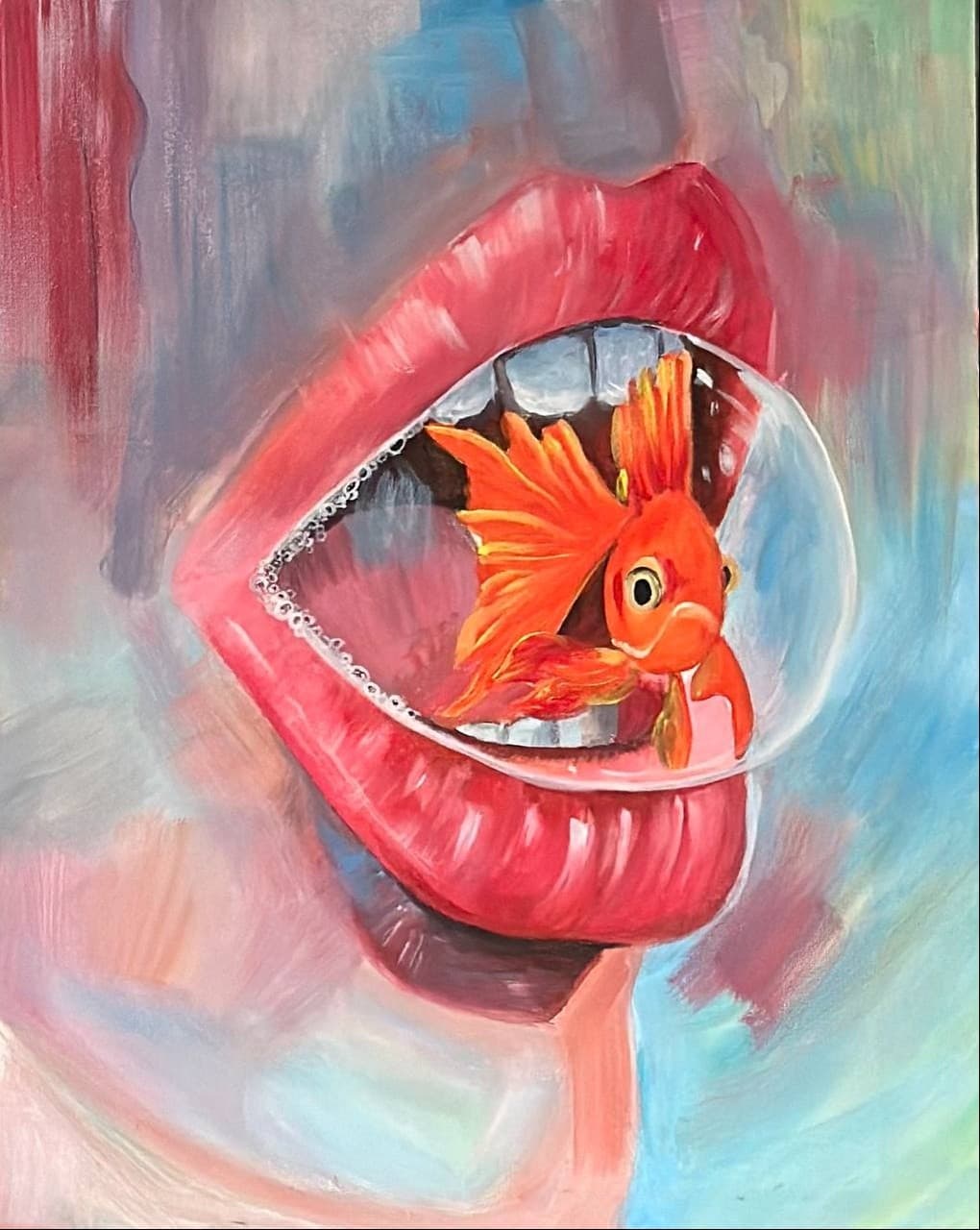 An open red mouth seen close up, teeth apart, holding a live goldfish inside a bubble of water. The ground behind is loose coral, pink and pale blue.